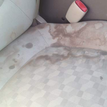 a reviewer's passenger seat in their car with mystery stains on it