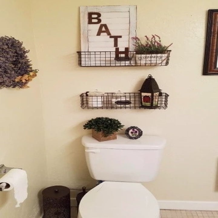 a reviewer's photo of the baskets hanging above a toilet