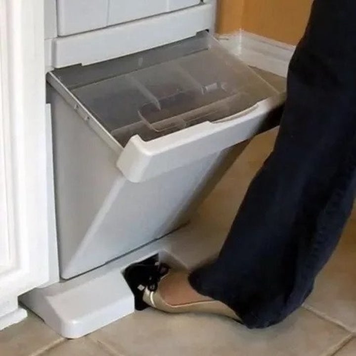a person using the foot pedal of the pet food holder