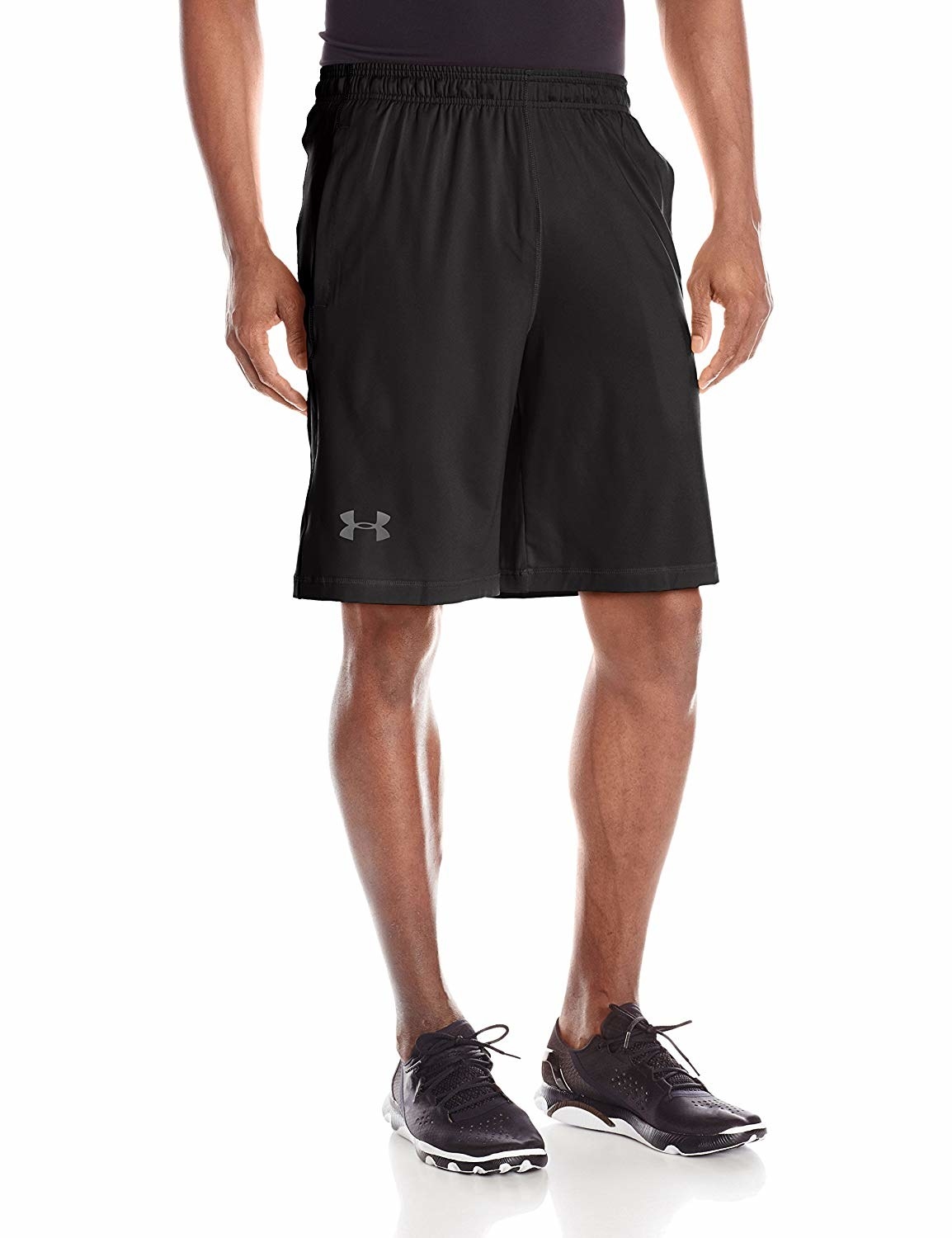 model wearing the knee-length shorts in black with a small Under Armor logo on the bottom right knee