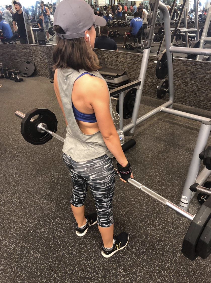 Reviewer wearing the tanks in grey at the gym