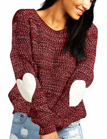 A model wearing the red sweater with white heart patches on the elbows