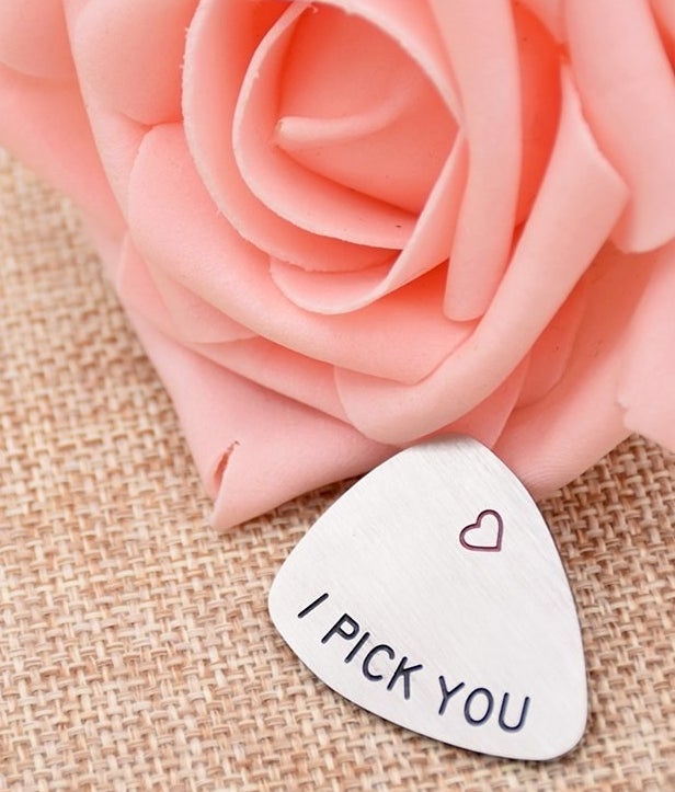Meal guitar pick with a heart and the words " I pick you"
