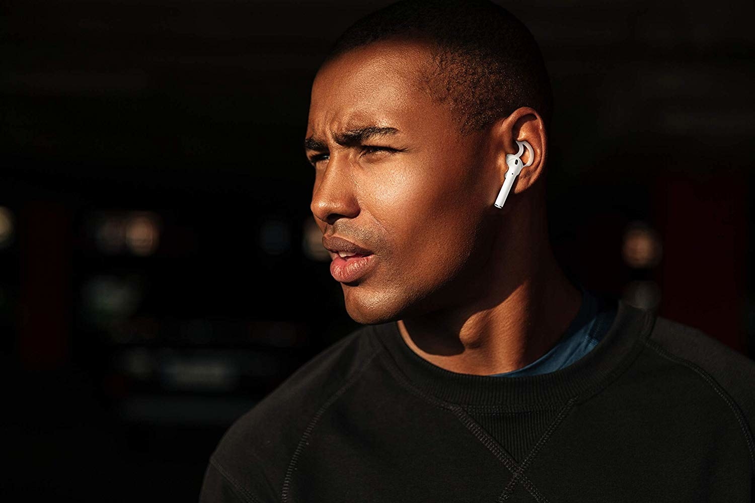 model wearing white ear hooks and Apple AirPods