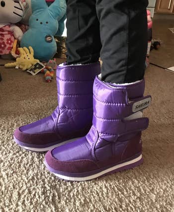 a reviewer wearing the boots in bright purple 