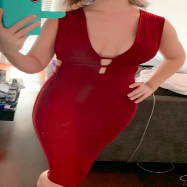 A reviewer wearing the knee-length dress in red