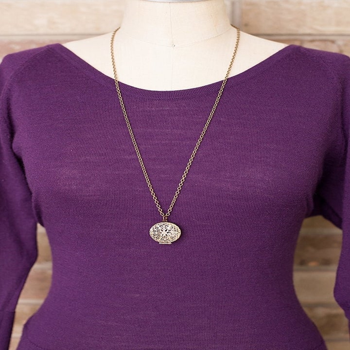 A mannequin wearing the circular pendant on a long chain