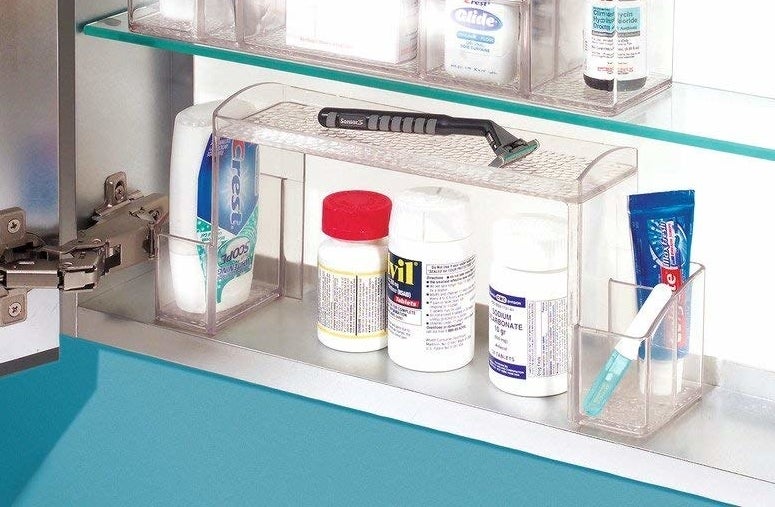 Three organizers sitting on the shelves of a medicine cabinet