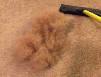 a reviewer's pile of hair after using the scrubbing brush