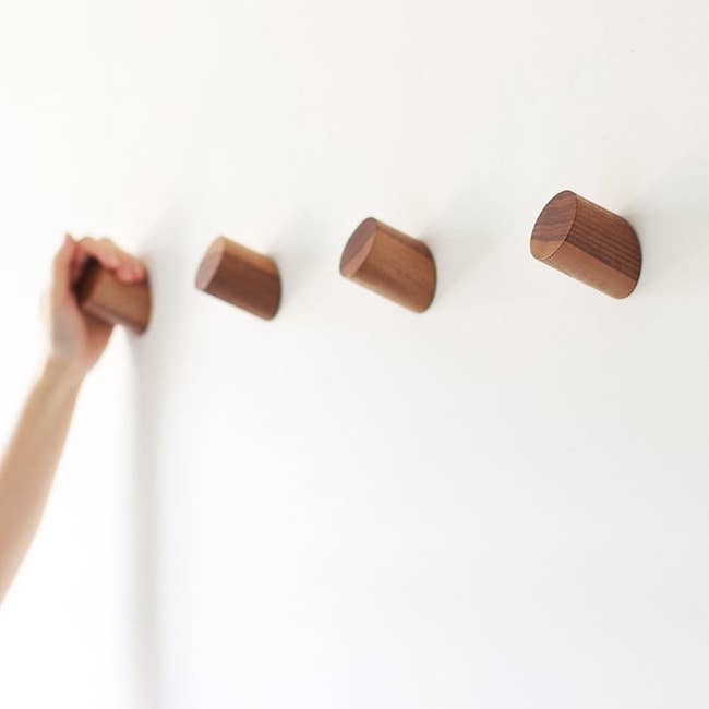 Four natural wood hooks on wall 