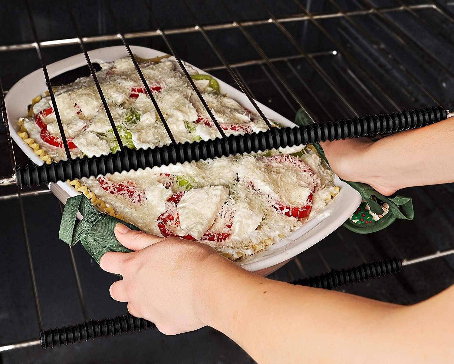 person taking dish out of oven with oven rack shields on oven racks