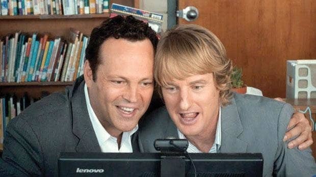 Vince Vaughn and Owen Wilson in The Internship hugging and looking at a screen