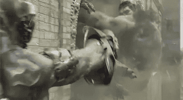 The Hulk crashing a guard against the exterior of a building