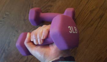 reviewer holding purple pair of three-pound weights