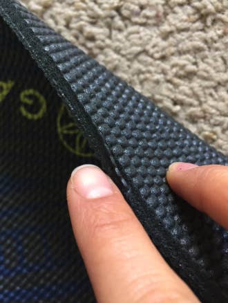 a reviewer showing the thickness of their yoga mat
