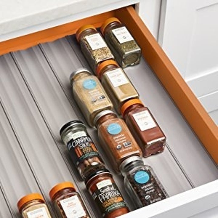 The same kitchen drawer filled with the liners and organized spices