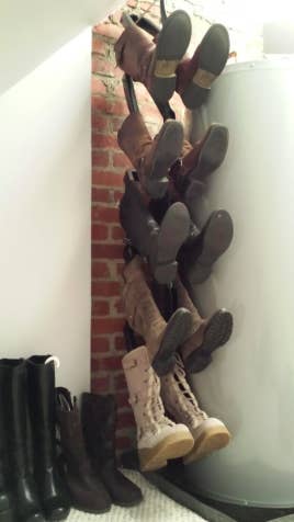 reviewer's pic of five pairs of knee-high boots hanging vertically in a closet