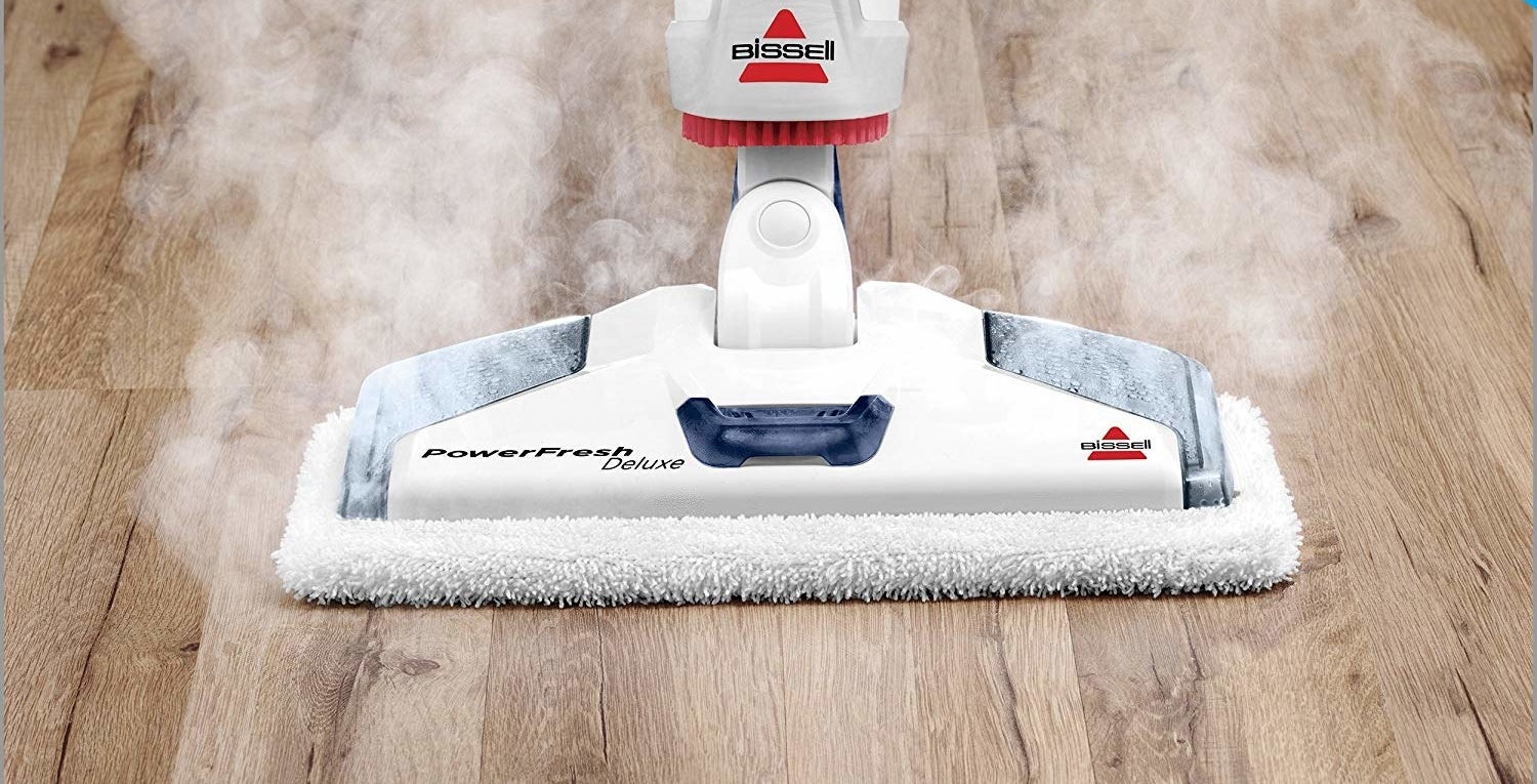 the steam mop being used on a wood floor