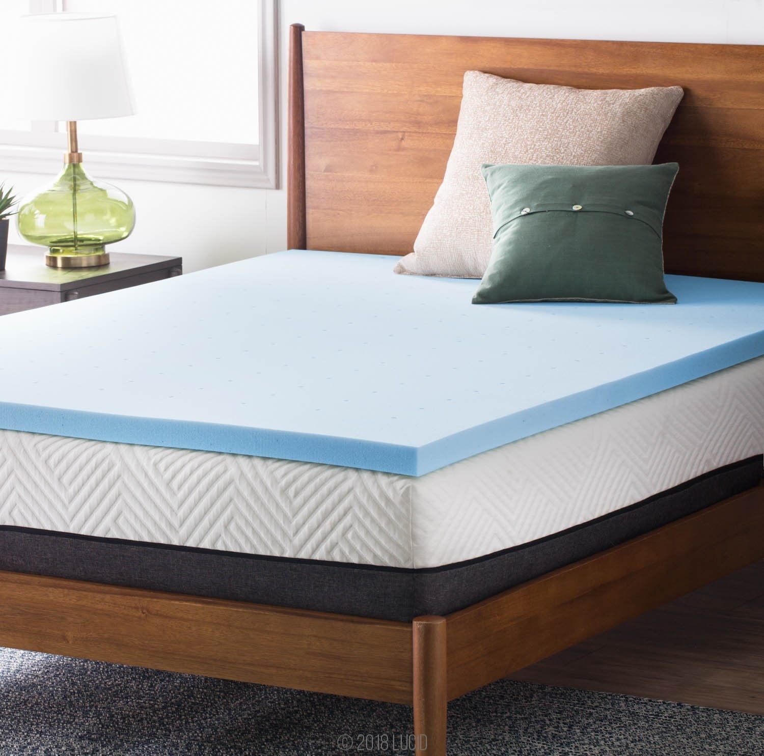 bed with blue mattress topper on top