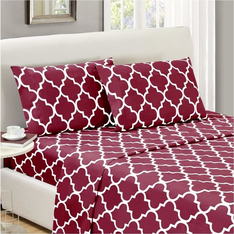 Red sheets and pillowcases with a white Quatrefoil design on a bed