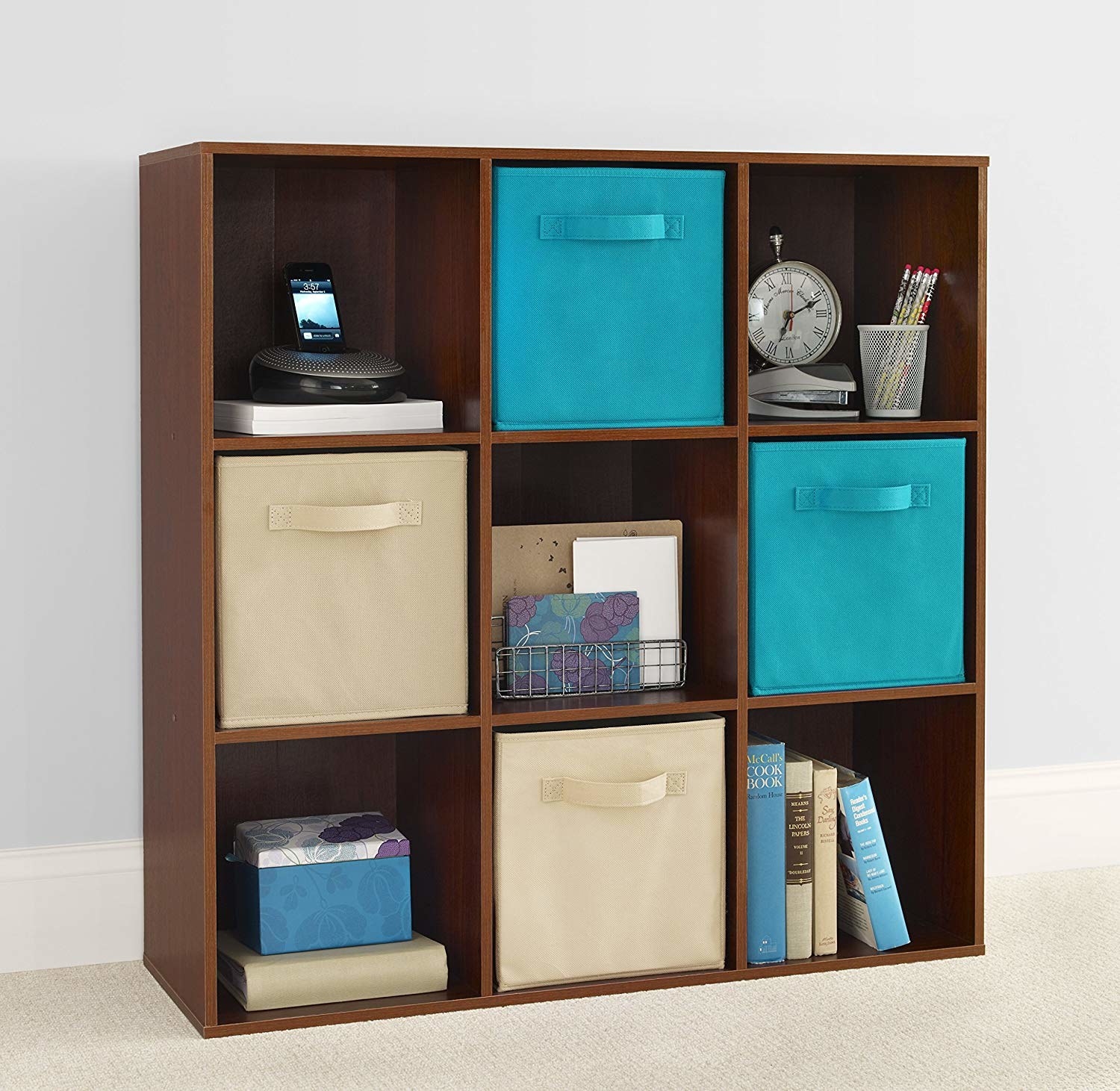 brown nine-cube organizer with four fabric drawers and other random stuff in each cube