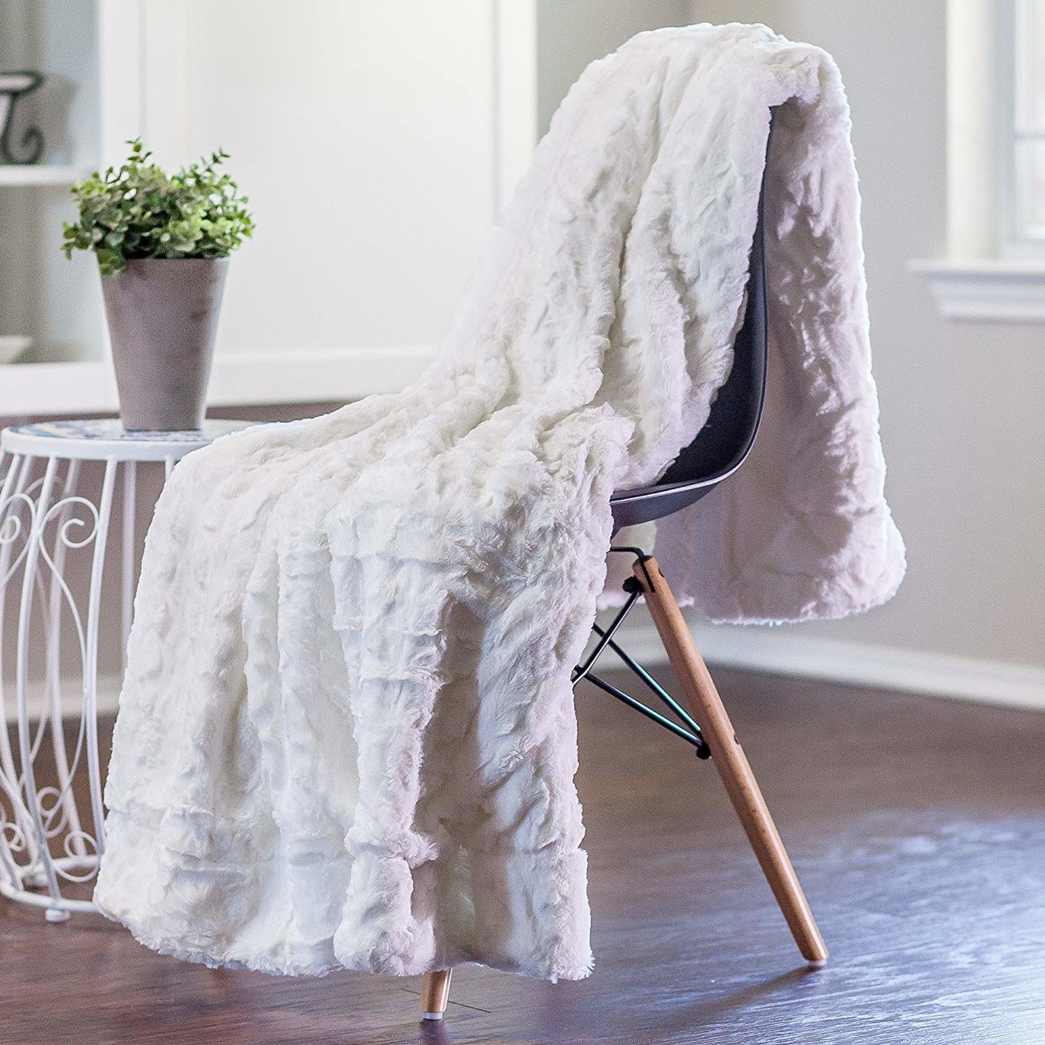 A fuzzy white blanket on a chair