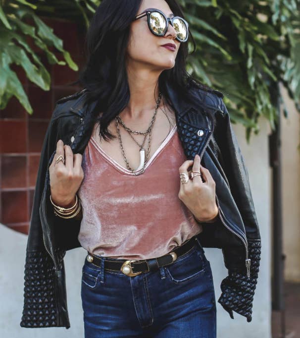 reviewer wearing the cami in pink with a leather jacket and jeans 