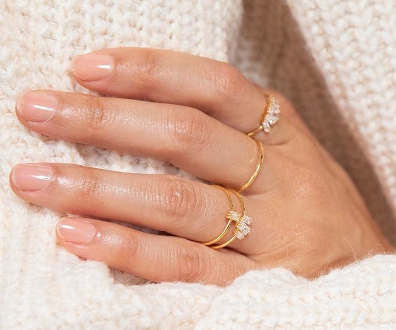 a hand wearing the dainty gold rings