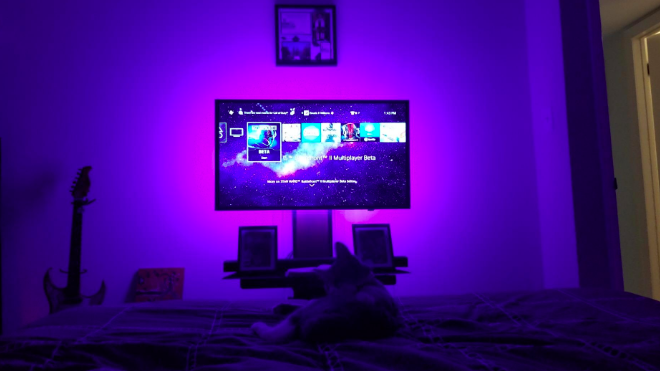 a reviewer image of a tv with purple lights behind it 