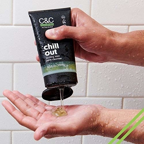 a hand squeezing the facial cleanser out of the bottle