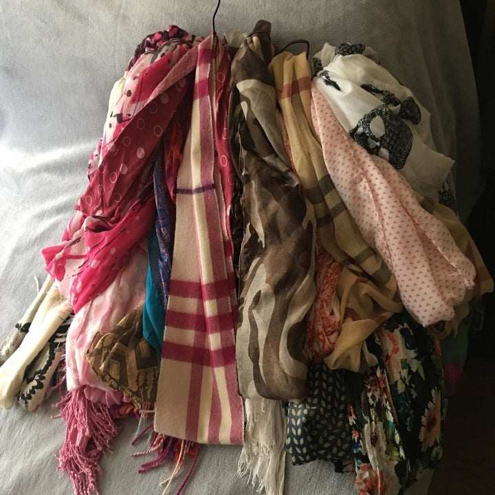 A reviewer showing a pile of scarves on the floor