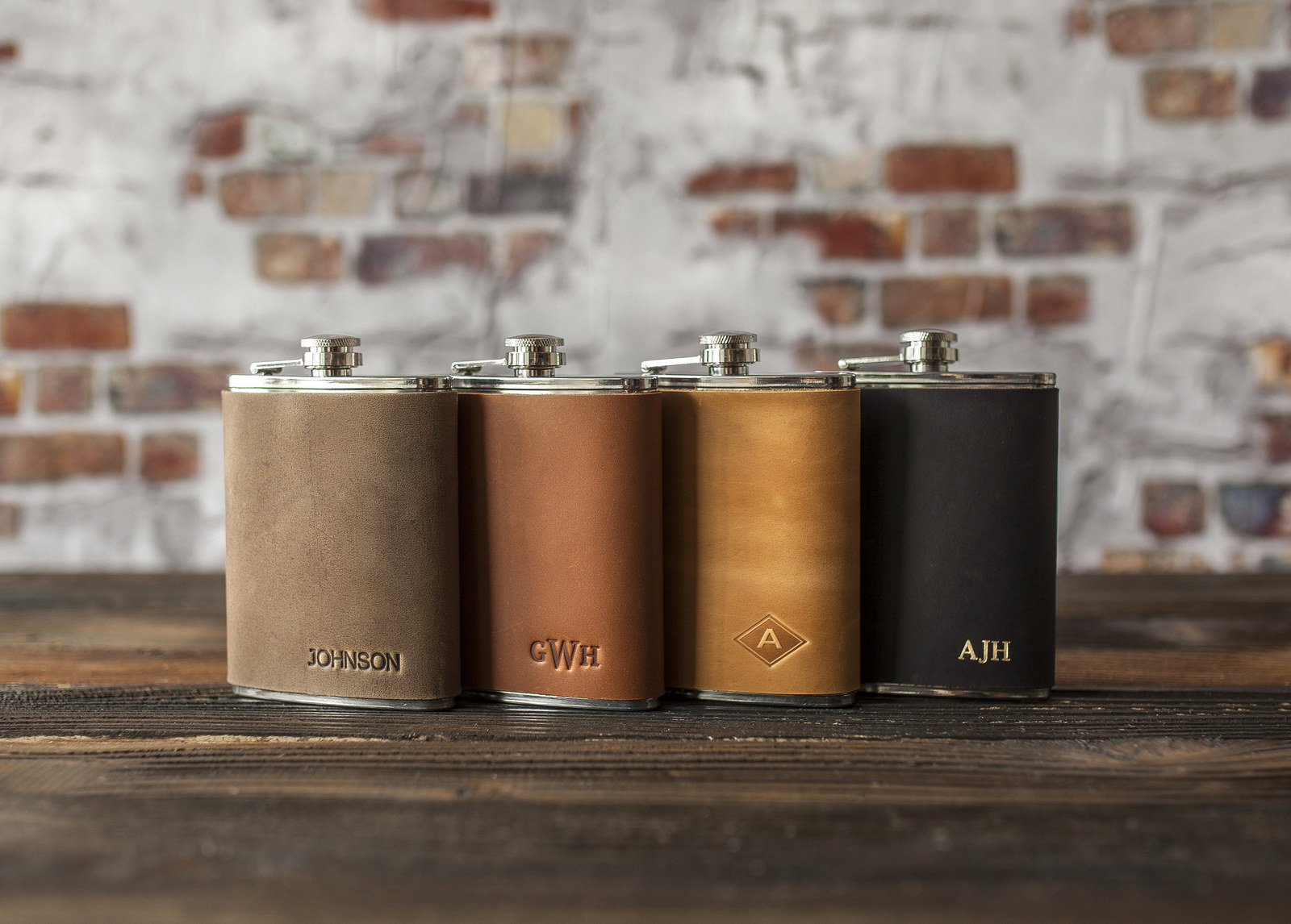 a line up of engraved flaks in tan, brown lighter brown, and black