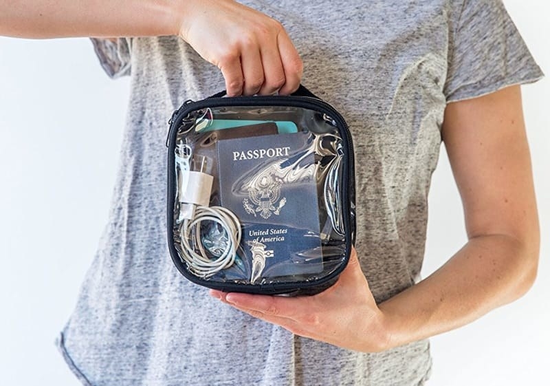 person holding the clear bag with different travel essentials stored away
