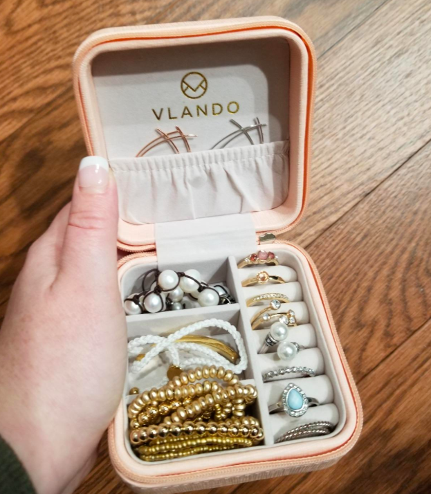 reviewer holding the small jewelry box open showing the compartments holding different jewelry