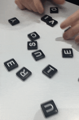 a gif of a buzzfeed editor playing bananagrams