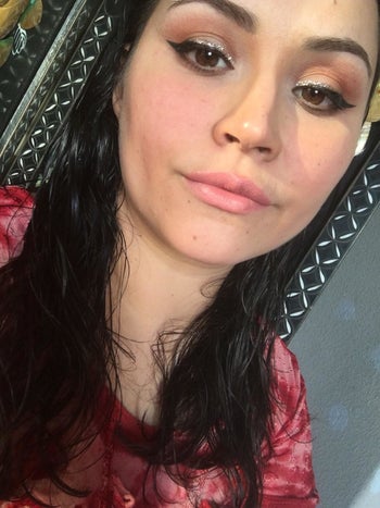 A reviewer selfie showing a winged eye makeup looking having used the stamp 