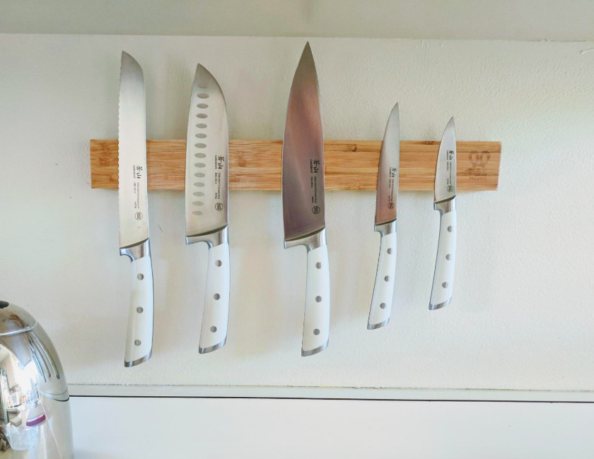 Reviewer photo of wooden magnetic strip holding reviewer&#x27;s knife collection 
