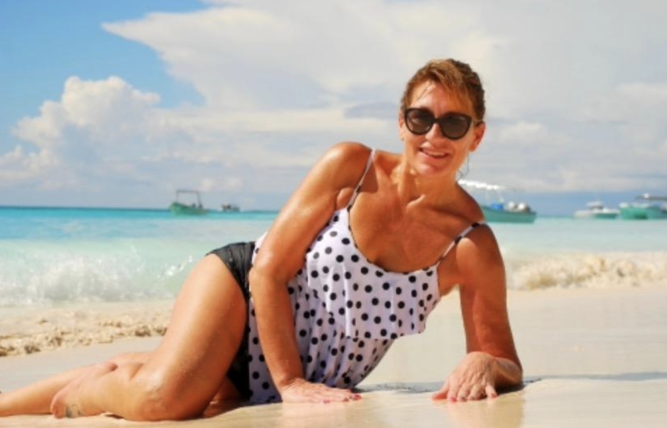 reviewer wearing the bathing suit with black short bottoms and a ruffle tank top in white with black polka dots