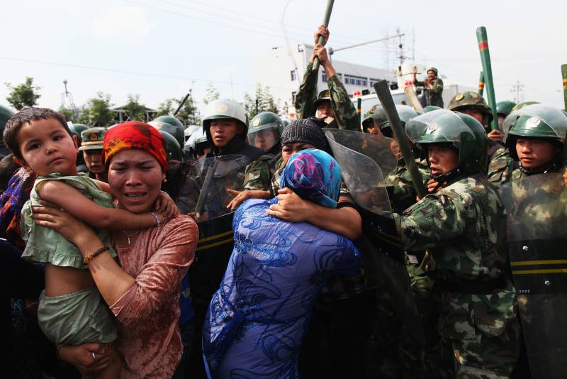 Chinese police officers push women during a protest in Urumqi in 2009.