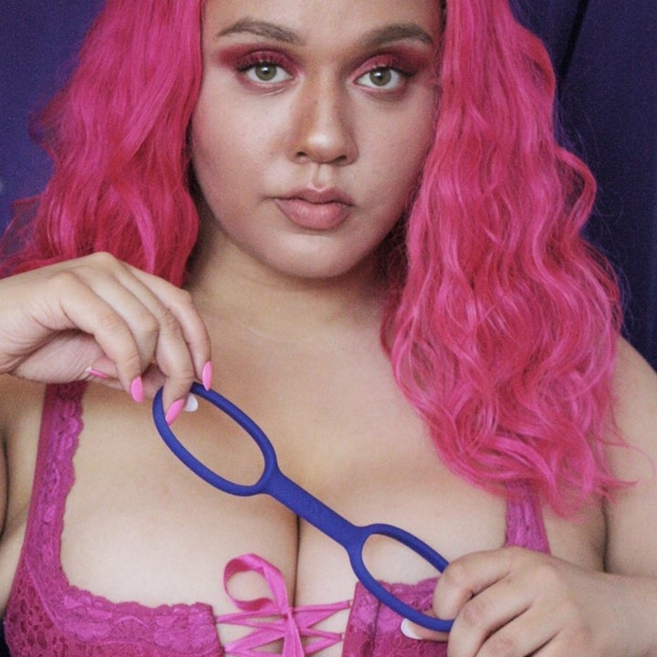 model holds handcuffs that look like stretchy silicone handcuffs 