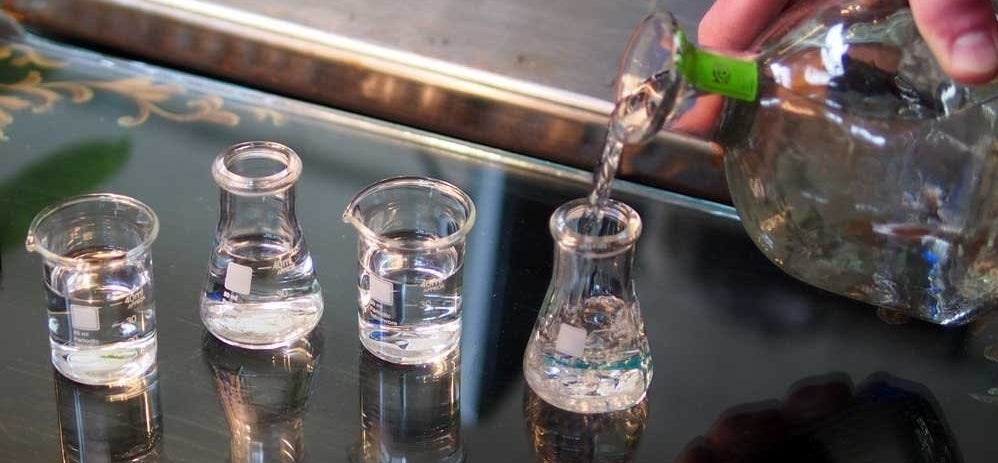 person pouring alcohol into shot glass