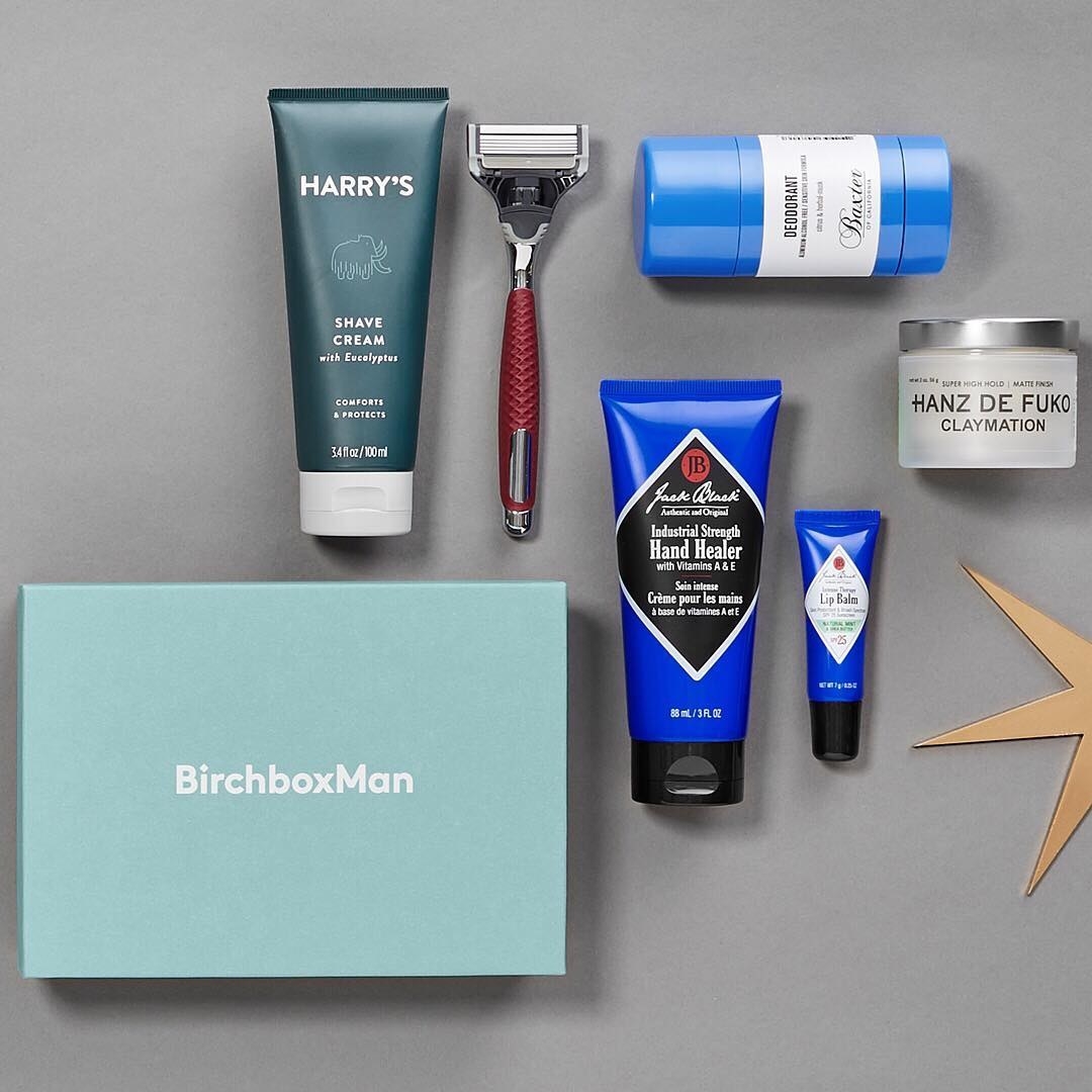 A  &quot;Birchbox Man&quot; box flatlay with Harry&#x27;s shaving cream and a razor, deodorant, hair cream, Jack Black hand cream, and lip balm