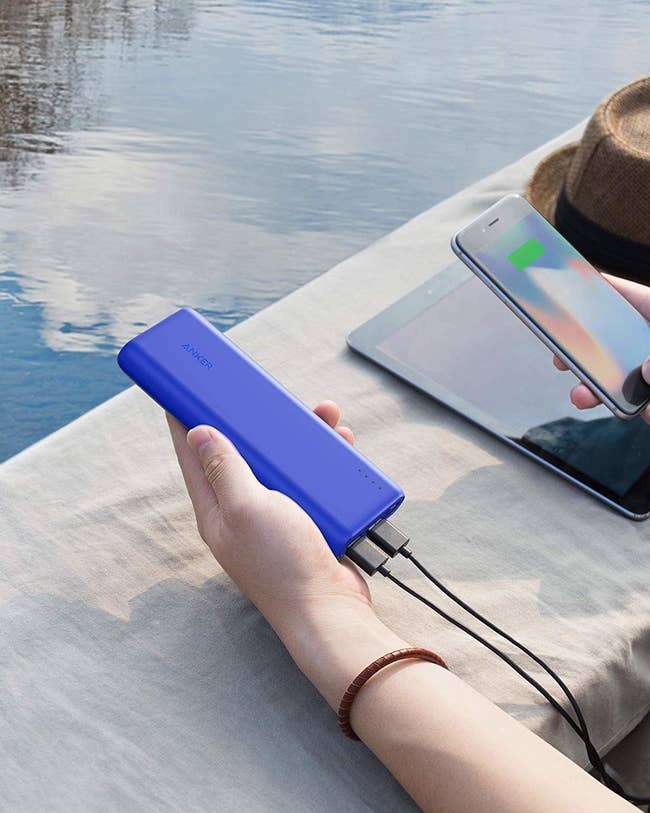 a hand holding the blue portable charger