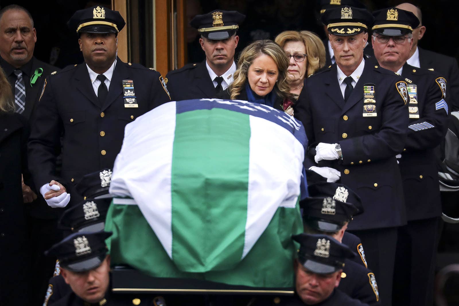 Leanne Simonsen, wife of fallen NYPD Detective Brian Simonsen, is escorted by officers as her late husband&#x27;s remains are carried out of the church following his funeral service on Feb. 20, in Hampton Bays, New York. Simonsen was killed by friendly fire while responding with fellow NYPD officers to a robbery at a store in Queens last week.