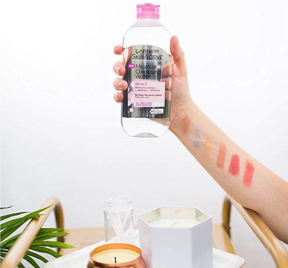 A hand holding the bottle of micellar water