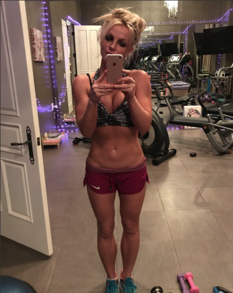 A photo from inside Britney&#x27;s gym in her previous home, which is a regular room with tile floors that holds workout equipment and has string lights running along the walls