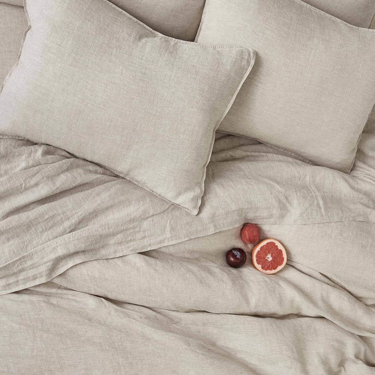 the linen sheets on a bed with fruit on the comforter 