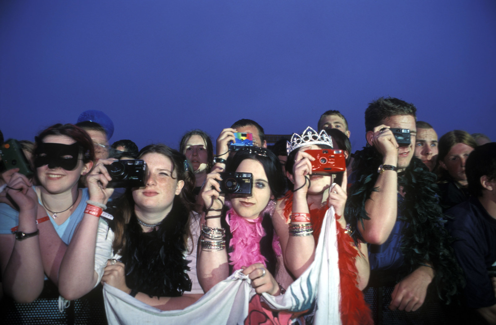 a row of people taking pictures on their cameras