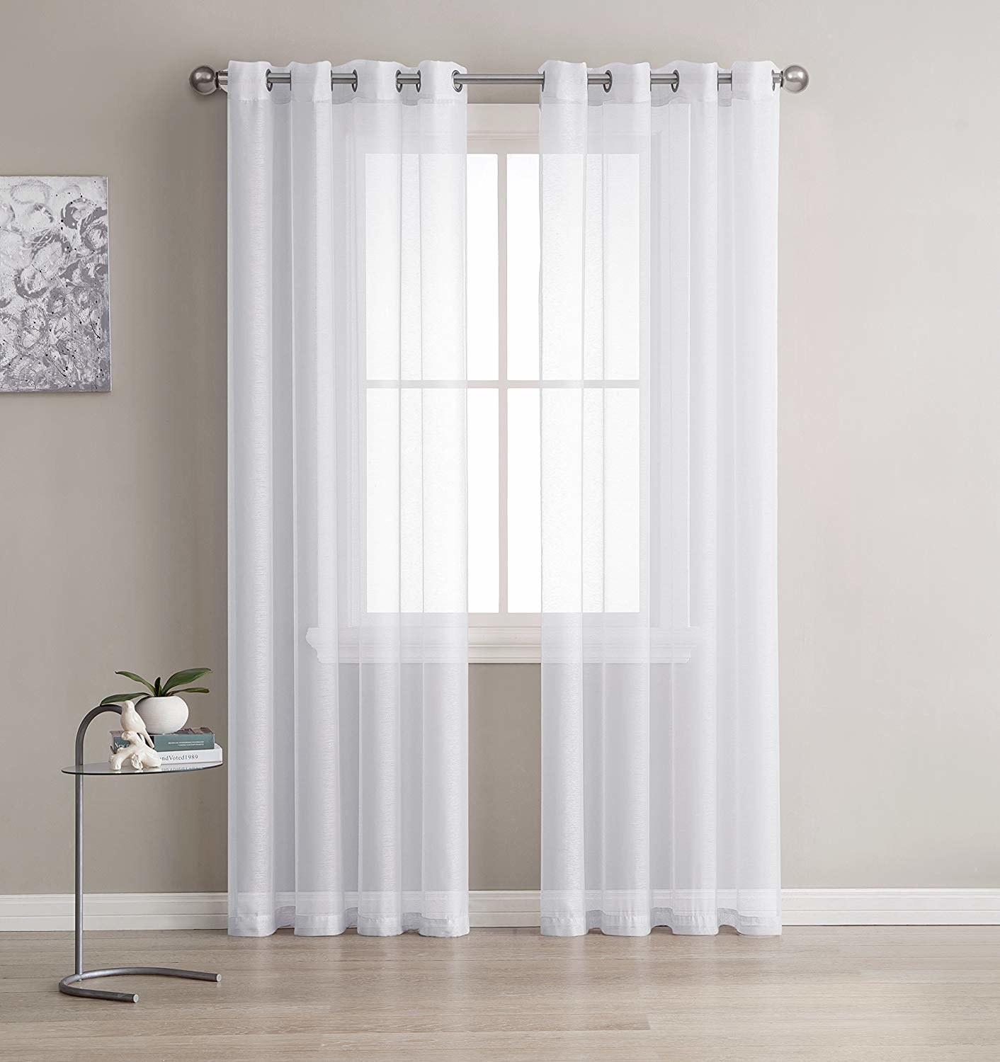 white semi-sheer curtains hanging over a window, letting light in