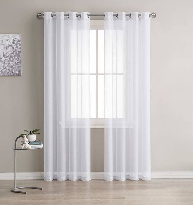 white semi-sheer curtains hanging over a window, letting light in